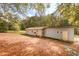 Large backyard view of a detached home with mature trees and fallen leaves at 105 Tranquillity Dr, Villa Rica, GA 30180