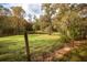 Picturesque backyard scene with a small pond, framed by lush greenery and a rustic fence at 105 Tranquillity Dr, Villa Rica, GA 30180