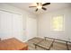 Bright bedroom featuring hardwood floors, a ceiling fan, and a large double-door closet for ample storage at 105 Tranquillity Dr, Villa Rica, GA 30180