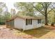 Back corner of the home with a chimney-like structure and fall leaves surrounding it at 105 Tranquillity Dr, Villa Rica, GA 30180