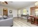 Cozy living room with a comfortable gray couch, hardwood floors, and a view into the dining area at 105 Tranquillity Dr, Villa Rica, GA 30180