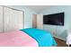 Bedroom with light pink bedding, teal blanket, and a large flat-screen TV at 113 Willow Hill Ln, Stockbridge, GA 30281