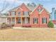 Brick two-story house with front porch and landscaped lawn at 6037 Addington Nw Dr, Acworth, GA 30101