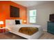 Bedroom with orange accent wall and white platform bed at 1334 Rogers Landing Rd, Lithonia, GA 30058