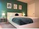 Bedroom with green accent wall and white platform bed at 1334 Rogers Landing Rd, Lithonia, GA 30058