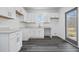 Modern kitchen with white cabinets, gray floors, and a window at 550 Paines Nw Ave, Atlanta, GA 30318