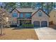 Two-story brick home with attached two-car garage and landscaped yard at 11850 Markham Way, Hampton, GA 30228