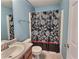 Clean bathroom with shower/tub, floral shower curtain, and wood vanity at 1734 Spring Hill Cv, Lithonia, GA 30058