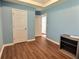 Light blue bedroom with wood-look floors, a closet, and access to other rooms at 1734 Spring Hill Cv, Lithonia, GA 30058