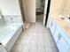 Bathroom featuring a large bathtub, tiled floors, and bright white vanities at 799 Blue Juniper Cir, Loganville, GA 30052