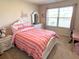 Charming bedroom with a striped bedspread, white furniture, and a window with blinds at 799 Blue Juniper Cir, Loganville, GA 30052