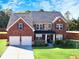 Charming brick two-story home with a two-car garage and well-manicured lawn at 799 Blue Juniper Cir, Loganville, GA 30052