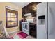 Kitchen with dark cabinets, white appliances, and tile floor at 812 Bartow Ct, Riverdale, GA 30274