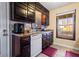 Kitchen with dark cabinets, white appliances, and tile floor at 812 Bartow Ct, Riverdale, GA 30274