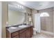 Bathroom featuring a granite vanity, large mirror, and tile surround shower at 1692 Branch Creek Cv, Lawrenceville, GA 30043