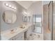 Bright bathroom featuring double sink vanities, a large mirror, and a tiled shower at 1692 Branch Creek Cv, Lawrenceville, GA 30043