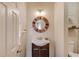 Bathroom with a round wooden mirror, sink, and toilet at 1692 Branch Creek Cv, Lawrenceville, GA 30043