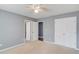 Spacious carpeted bedroom with white trim, multiple closets, and grey painted walls at 1692 Branch Creek Cv, Lawrenceville, GA 30043