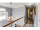 Hallway with a chandelier, natural light, and hardwood floors to different areas of the house at 1692 Branch Creek Cv, Lawrenceville, GA 30043