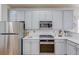 Well-equipped kitchen featuring stainless appliances, white countertops, and grey cabinets at 1692 Branch Creek Cv, Lawrenceville, GA 30043