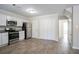 Galley kitchen with white cabinets, stainless steel appliances, and grey wood-look flooring at 3049 Flat Shoals Rd, Atlanta, GA 30349