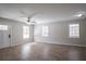 Spacious living room with wood-look floors, neutral paint, a ceiling fan, and three windows at 3049 Flat Shoals Rd, Atlanta, GA 30349