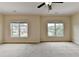 Bright bedroom with neutral walls, carpeting, and two large windows at 7890 Royal Melbourne Way, Duluth, GA 30097