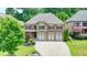 Brick two-story house with three-car garage and landscaped yard at 7890 Royal Melbourne Way, Duluth, GA 30097