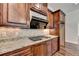 Kitchen features gas cooktop, granite countertops, and dark wood cabinets at 7890 Royal Melbourne Way, Duluth, GA 30097