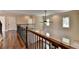 Upstairs hallway with hardwood floors and iron railing at 7890 Royal Melbourne Way, Duluth, GA 30097