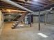 Unfinished basement with open space, concrete floor, and wooden stairs at 6242 Prestley Mill Rd, Douglasville, GA 30134