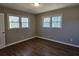 Bright bedroom featuring hardwood floors and two windows at 6242 Prestley Mill Rd, Douglasville, GA 30134