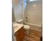Bathroom featuring a shower-tub combo, vinyl flooring, and a wooden vanity at 7981 Gossamer Dr, Fairburn, GA 30213