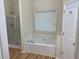 Bright bathroom with a soaking tub beneath a window and a glass-enclosed shower at 7981 Gossamer Dr, Fairburn, GA 30213