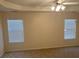 A bedroom with a ceiling fan and two windows allowing natural light at 7981 Gossamer Dr, Fairburn, GA 30213