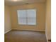 Well-lit bedroom featuring a large window with blinds and neutral carpeting at 7981 Gossamer Dr, Fairburn, GA 30213