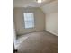 This bedroom features neutral carpet, a large window, and a sloped ceiling at 7981 Gossamer Dr, Fairburn, GA 30213