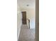 Upstairs hallway with neutral carpet and a view into a bedroom, offering a sense of space at 7981 Gossamer Dr, Fairburn, GA 30213