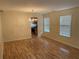 Open-concept living room with hardwood floors and large windows for natural light at 7981 Gossamer Dr, Fairburn, GA 30213