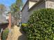 The side of the property is lined with mature shrubs, providing a sense of privacy and greenery at 7981 Gossamer Dr, Fairburn, GA 30213