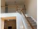 Open staircase with wood banister and neutral carpet, offering a seamless transition between floors at 7981 Gossamer Dr, Fairburn, GA 30213