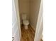 Compact toilet room featuring wood vinyl flooring and freshly painted walls at 7981 Gossamer Dr, Fairburn, GA 30213