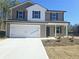 Two-story house with a white and brown exterior, a two-car garage, and landscaping at 105 Heyman Dr, Covington, GA 30016