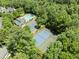 A high angle shot of a swimming pool, tennis court, and clubhouse nestled among a mature tree canopy at 1479 Brentwood Dr, Marietta, GA 30062