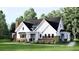 Charming farmhouse-style home with white siding, brick accents, and a well-manicured front yard at 2012 Ripple Park Bnd, Canton, GA 30114