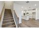 View of the stairway, hardwood-style floor, and kitchen with stainless steel appliances at 4669 Red Lion Pl, Lawrenceville, GA 30044