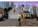 Ranch style home with two car garage and mature landscaping at dusk at 1540 Cloverleaf Pl, Cumming, GA 30041