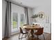Bright dining room features a round wooden table with four brown leather chairs and access to backyard at 8238 Walnut Hall Dr, Fairburn, GA 30213