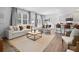 Open concept living room with a large sofa and view into kitchen and dining area at 8238 Walnut Hall Dr, Fairburn, GA 30213