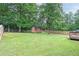 Expansive backyard featuring mature trees, green grass, a shed, and a wooden fence at 1167 Mcclung Rd, Hiram, GA 30141